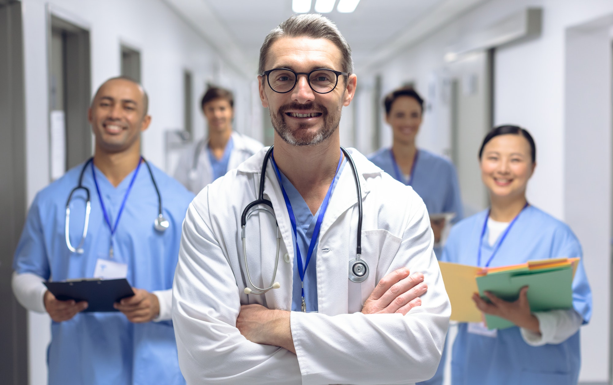 Diverse medical team of doctors looking at camera while holding clipboard and medical files